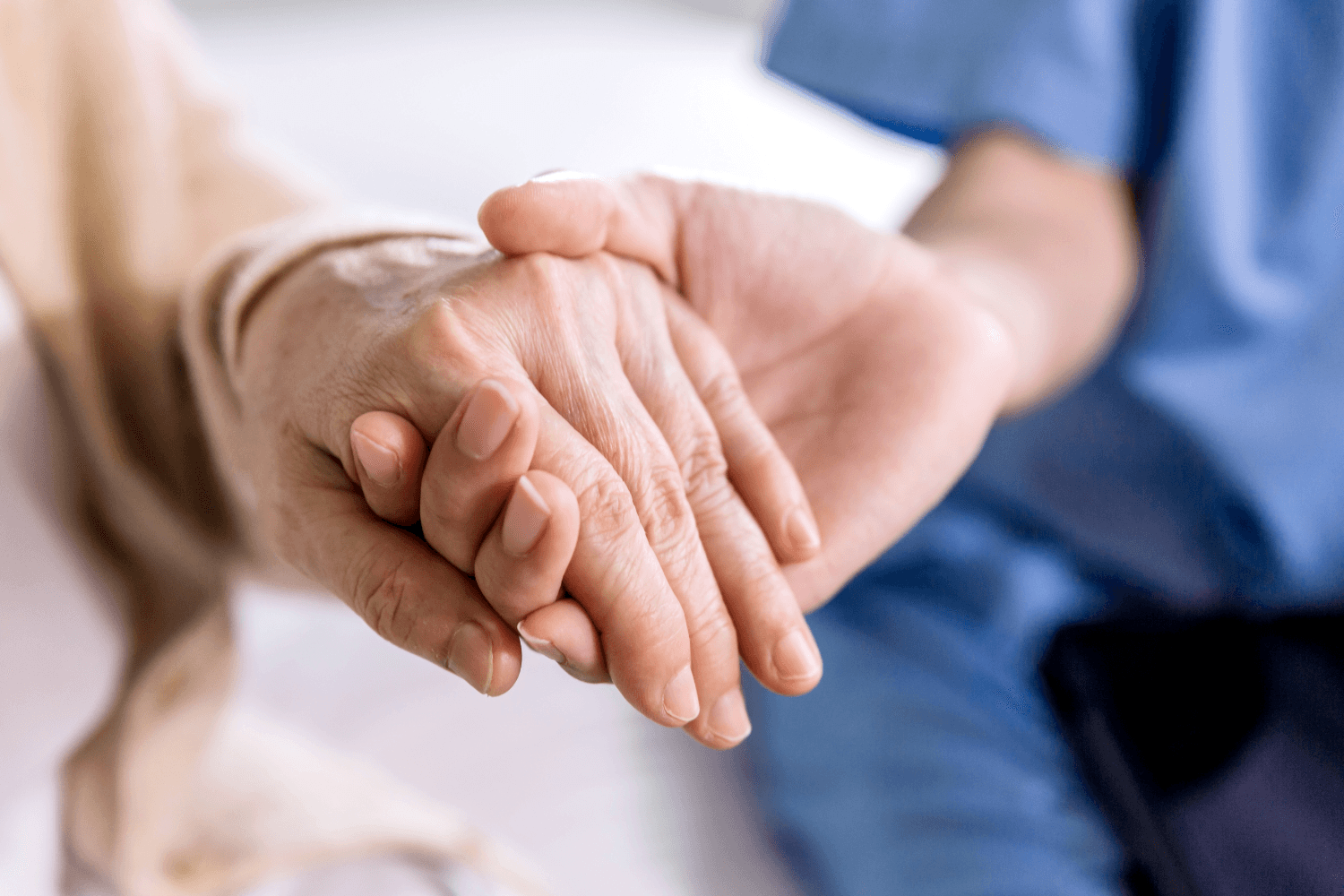 Image of a care worker holding hand for support