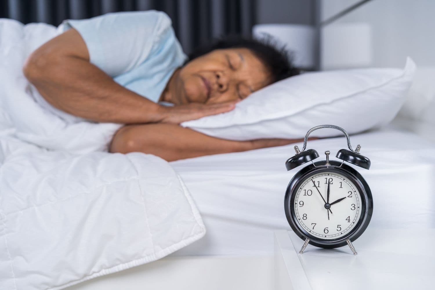 Woman trying to get to sleep with alarm clock