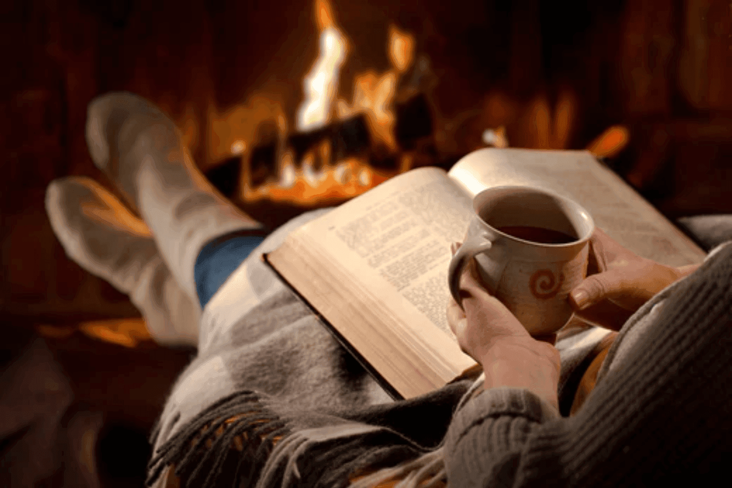 Woman reading next to a fire