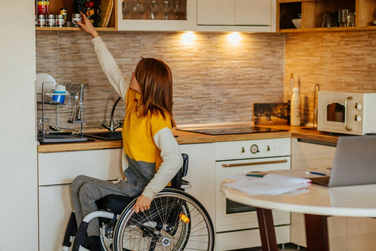 Woman using a wheelchair cooking in the kitchen