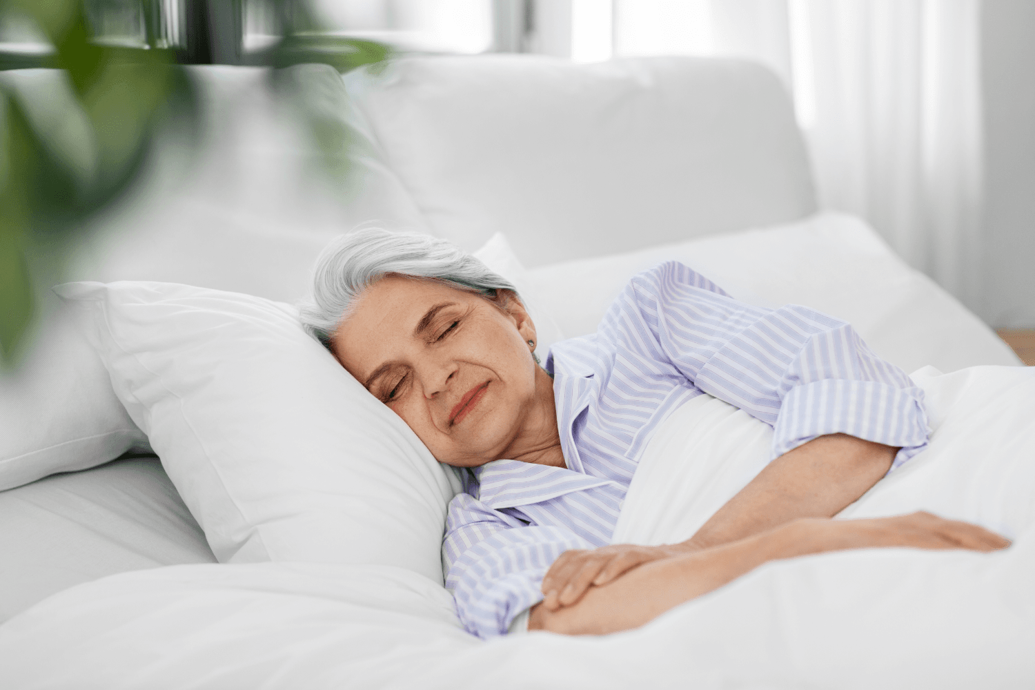 Woman sleeping in a bed with white bedding