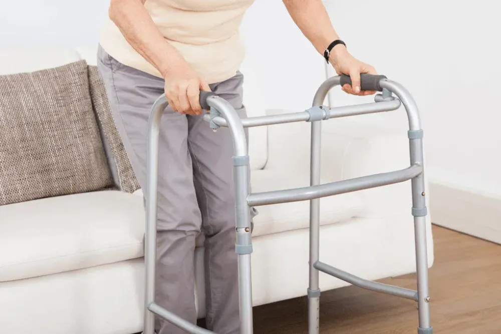 Lady getting up from seat with her zimmer frame
