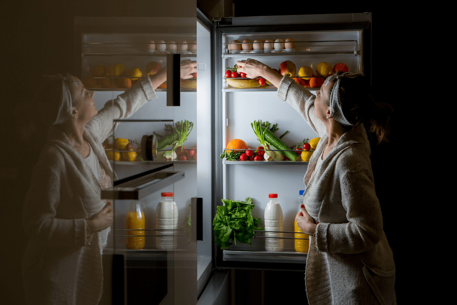 Woman looking for food to eat in fridge late at night