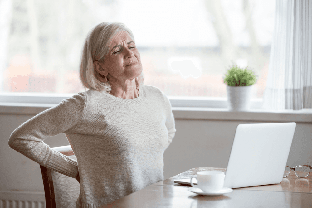 Woman in pain due to sitting position on chair