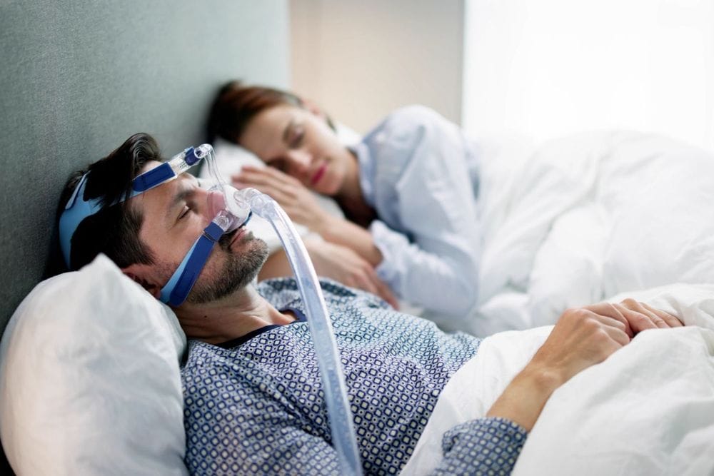 man sleeping with a CPAP machine