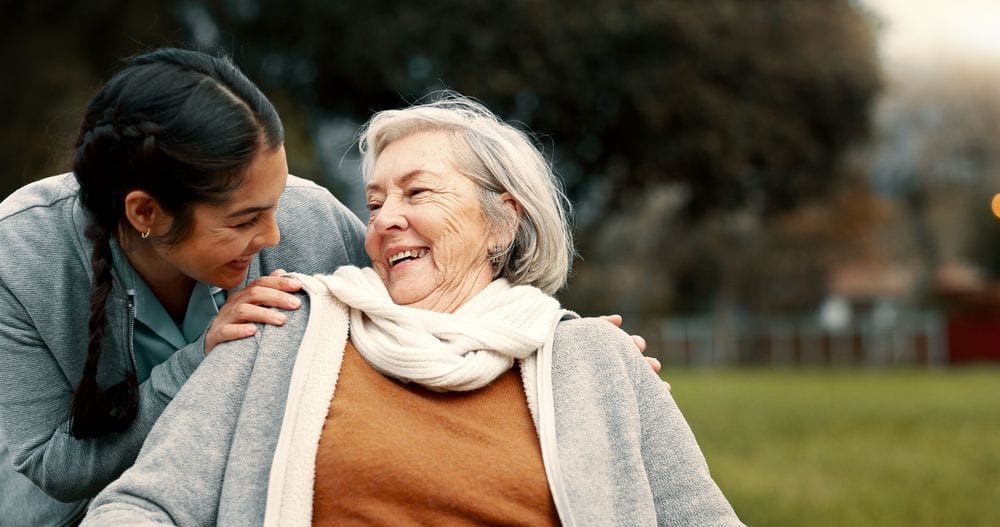 Young woman leading over old woman smiling at each other