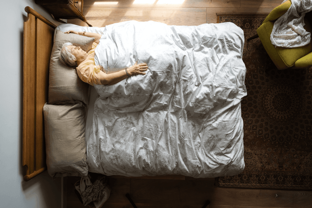 Ariel view of older woman in bed daytime napping