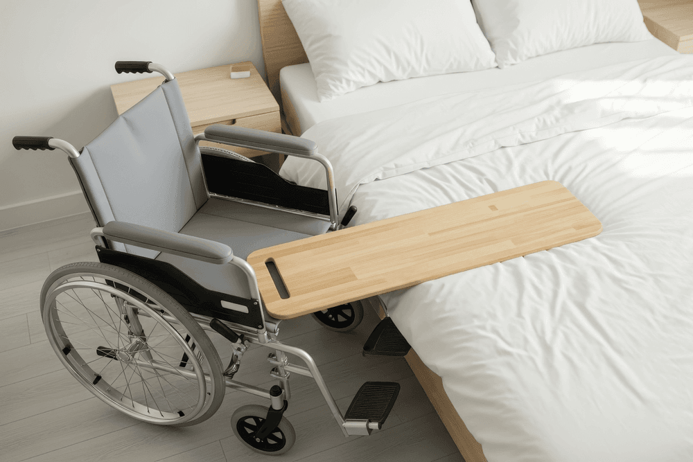 Transfer board balanced on wheelchair seat and bed
